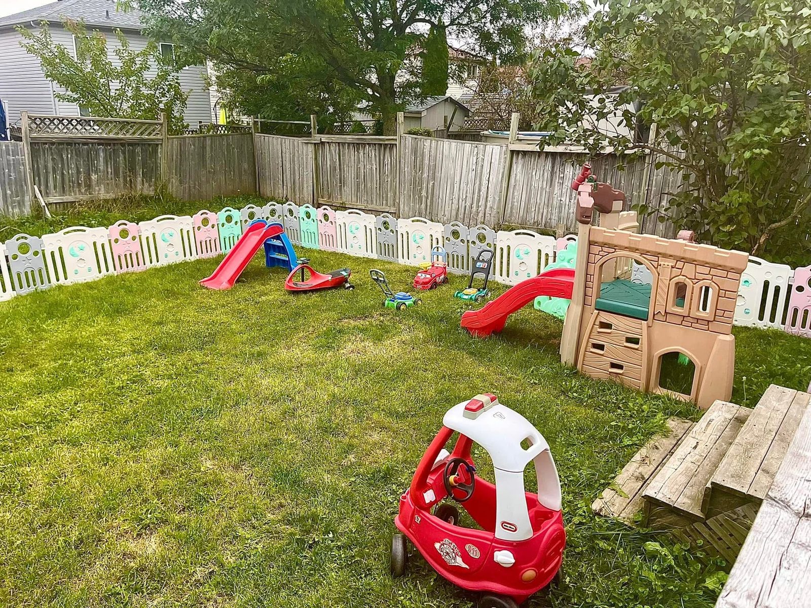 Large fenced backyard with slides and play equipment
