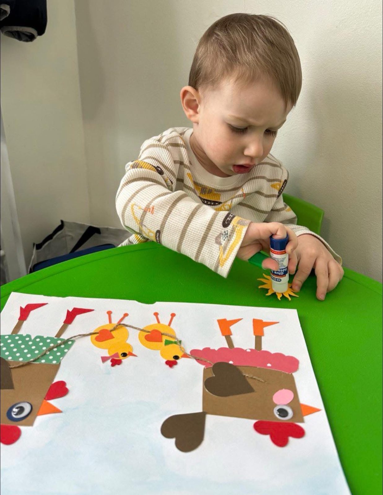 Toddler doing a paper gluing craft