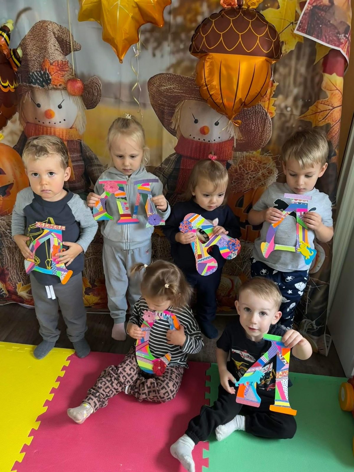 Children holding handmade alphabet letter crafts